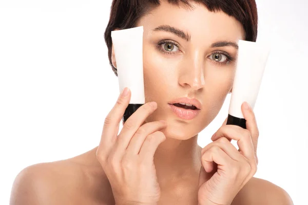 Beautiful brunette is holding a skin care product in her hands — Stock Photo, Image