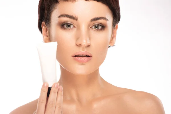 Beautiful brunette is holding a skin care product in her hands — Stock Photo, Image