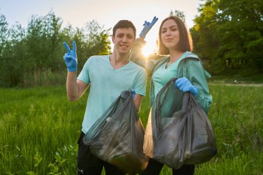 Plogging kavramı. Bir oğlan ve kız ormandan çöp topluyorlar. Çöp torbasında çöp topluyorlar.