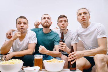 Cips patlamış mısır yerken ve soğuk bira içerken Tv izleyen arkadaşlar