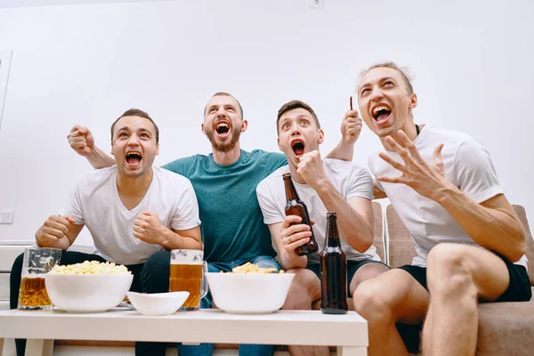 Friends watching Tv  while eating chips popcorn and drinking some cold beer — Stock Photo, Image