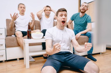 Cips patlamış mısır yerken ve soğuk bira içerken Tv izleyen arkadaşlar