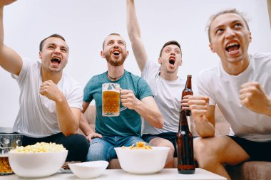 Cips patlamış mısır yerken ve soğuk bira içerken Tv izleyen arkadaşlar