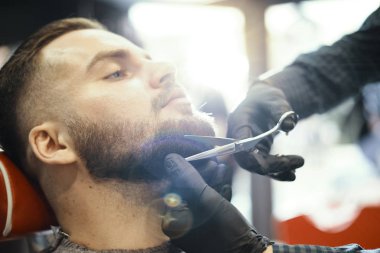 bir adam bir saç kesimi yapıyor ve sakal şekillendirme 