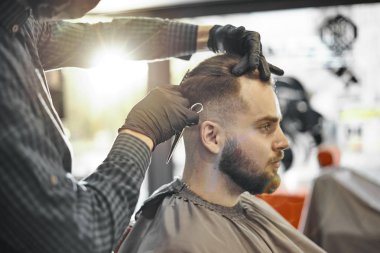 bir adam bir saç kesimi yapıyor ve sakal şekillendirme 