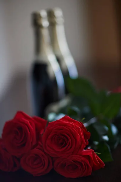 Botellas de champán y un ramo de rosas rojas — Foto de Stock