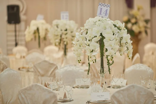 Mesas de casamento no restaurante decorado com orquídeas Imagens De Bancos De Imagens