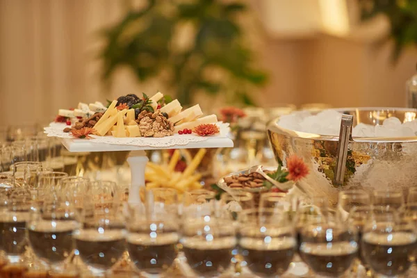 Nombreuses collations et verres différents avec champagne sur une table de mariage — Photo