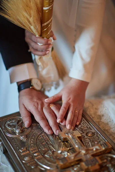 Groom and bride hold hands on Bible — Stock Photo, Image