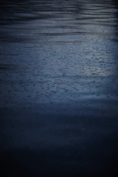 Gotas de lluvia caen sobre el agua en el lago —  Fotos de Stock