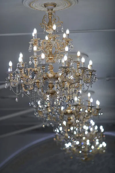 Grandes candelabros de cristal chapados en oro en un restaurante — Foto de Stock