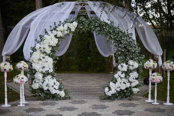 Arco de boda de flores blancas y tul en la naturaleza — Foto de Stock