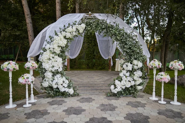자연계에서 볼 수있는 하얀 꽃 과 물갈퀴의 결혼식 아치 스톡 사진
