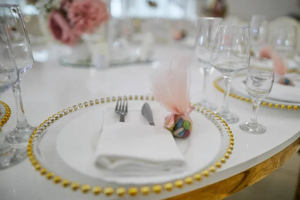 Assiette blanche avec bord doré, verres et couverts sur une table — Photo