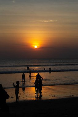 Gün batımında Bali Kuta plaj, İnsanlar oynuyor ve zevk