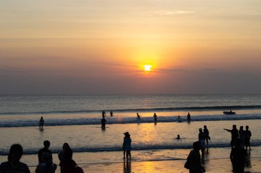 Gün batımında Bali Kuta plaj, İnsanlar oynuyor ve zevk
