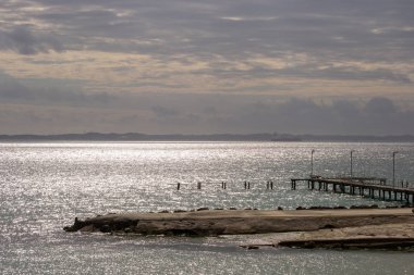 Bulutlu bir günde gün batımında deniz manzarası