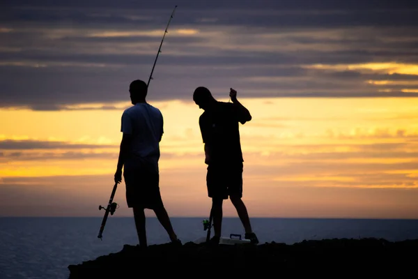 夕暮れ時のビーチで釣り 人の男のシルエット — ストック写真