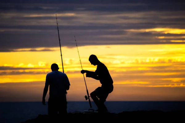 夕暮れ時のビーチで釣り 人の男のシルエット — ストック写真