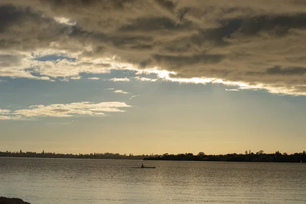 Isolated landscape at sunset with clouds and water