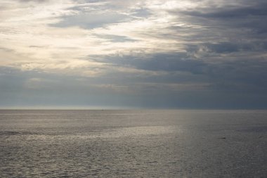 Bulutlu bir günde gün batımında plaj Manzara