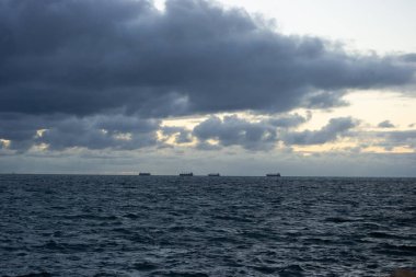 Bulutlu bir günde gün batımında plaj Manzara