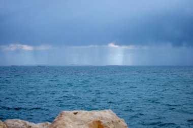 Bulutlu bir günde gün batımında plaj Manzara