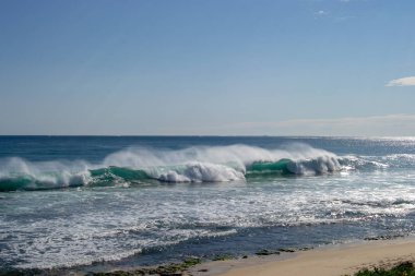 Güneşli ve rüzgarlı bir günde bir plaj Manzara