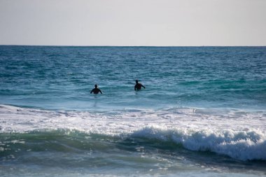 Avustralya sahilinde sörf yapan bir adamın manzarası