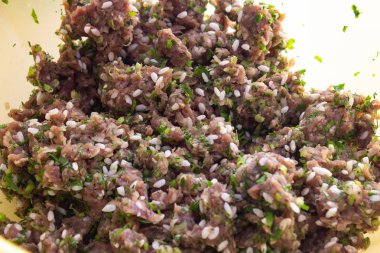 escasty içinde et. Kıyma içine yeşillik ekleyin. Kadın kıyma otlar ekler