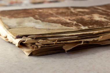 Beyaz yüzeyli eski bir kitap. Darmadağınık kitap. Beyaz bir yüzeyde yıpranmış bir kitap. Beyaz arka plan üzerine yıpranmış bir kitap