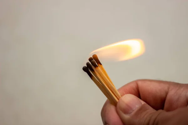 Lit match in hand. A lit match on a white background. Lighted match in hand on white background. Burning match in hand. Burning match on white background