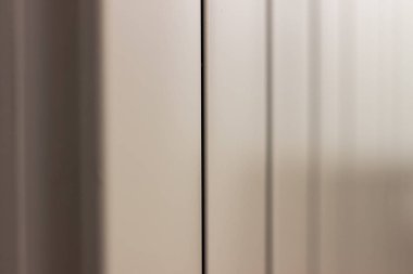 Kırmızı duvarın arka planında eski beyaz dökme demir pil. Beyaz duvara monte radyatör. siyah çizgili beyaz doku