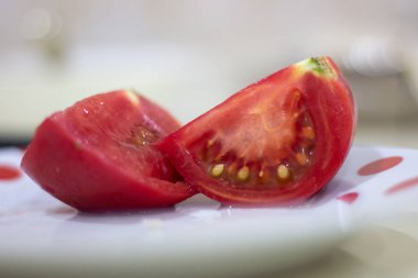 Tabakta iki dilim domates. İki dilim domates. Tabakta domates var. Kırmızı domatesiki hisse