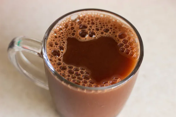 Güzel kahve süt köpüğü. Koyu bir arka plan üst görünümünde şeffaf bir cam süt ile Kahve. Şeffaf cam üst görünümde koyu kahve. Koyu köpüklü kahve — Stok fotoğraf