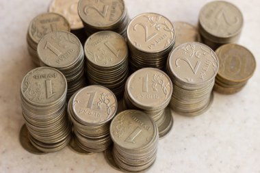 güneşli bir günde ahşap yüzeyüzerinde beyaz ve sarı metal Rus sikkeler. Beyaz bir yüzeyde metalik rubleler. Beyaz bir yüzeyde Rus parası. Rus metal parası. Rus metal rublesi