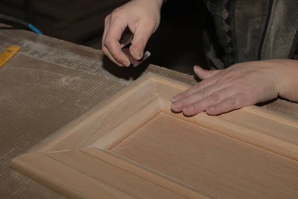 manual polishing of wooden furniture of a facade made of solid beech wood in joinery