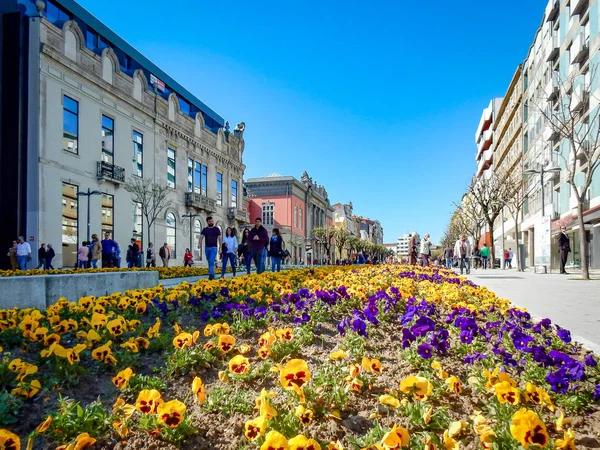 Flowers and people walking in Liberdade Avenue, Avenida, in Braga. Portugal