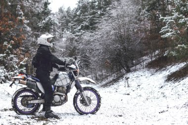 Kış motokrosunda motosikletli bir binici. Karlı bir ormanda kaydım. Enduro motosikletinin tekerleklerinin altındaki kar. off road dual spor seyahat turu, aktif yaşam tarzı konsepti