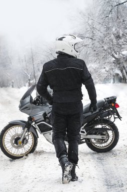 Sürücü ve macera motosikleti. Kış eğlencesi Karlı bir gün. Kar motosikleti. Enduro. off road dual spor seyahat turu, aktif yaşam tarzı konsepti. Kışlık giysiler, ekipmanlar, dikey fotoğraf