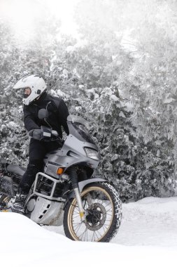 Macera motosikletli bir sürücü. Kış eğlencesi Karlı bir gün. Kar yoluna çık. off road. Seyahat turu, aktif yaşam tarzı konsepti. Kışlık giysiler, ekipman, kopya spase, dikey fotoğraf