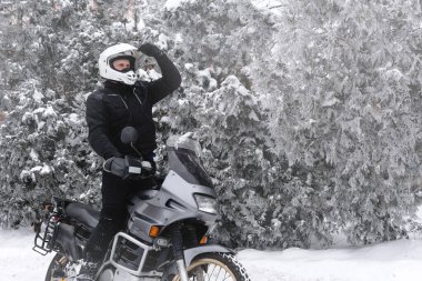 Macera motosikletli bir binici. Kış eğlencesi Karlı bir gün. Motorsikletin tekerleklerinin altındaki kar. Enduro. off road dual spor seyahat turu, aktif yaşam tarzı konsepti. Kış giysileri, ekipmanlar