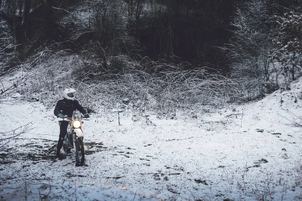 Kış motokrosunda motosikletli bir binici. Karlı bir ormanda kaydım. Enduro motosikletinin tekerleklerinin altındaki kar. off road dual spor seyahat turu, aktif yaşam tarzı konsepti