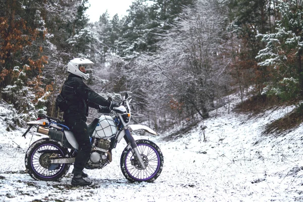 Kış motokrosunda motosikletli bir binici. Karlı bir ormanda kaydım. Enduro motosikletinin tekerleklerinin altındaki kar. off road dual spor seyahat turu, aktif yaşam tarzı konsepti