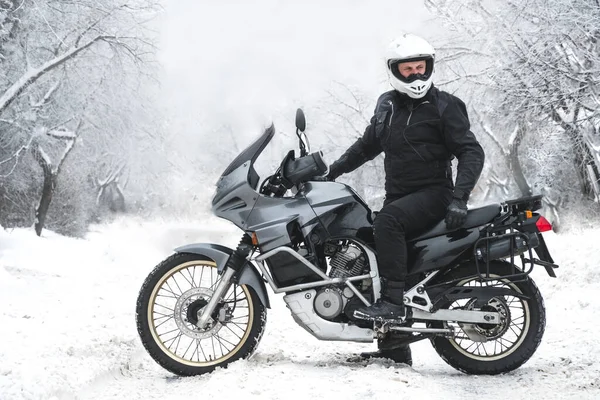 Macera motosikletli bir binici. Kış eğlencesi Karlı bir gün. Motorsikletin tekerleklerinin altındaki kar. Enduro. off road dual spor seyahat turu, aktif yaşam tarzı konsepti. Kış giysileri, ekipmanlar