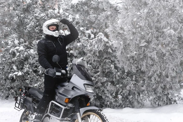 Macera motosikletli bir binici. Kış eğlencesi Karlı bir gün. Motorsikletin tekerleklerinin altındaki kar. Enduro. off road dual spor seyahat turu, aktif yaşam tarzı konsepti. Kış giysileri, ekipmanlar