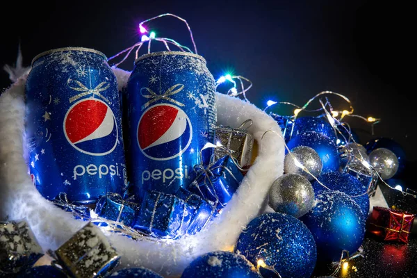 Khmelnytskyi, Ukrayna - 13 Aralık 2019: Siyah arka planda demir şişe pepsi içeceği. Yeni 2020 konsepti, Noel süsleri ve Noel Baba şapkası, çelenk. mesaj için yer. Alüminyum kutu