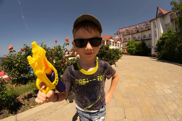 Rapaz Com Uma Pistola Água Tiro Legal Usando Óculos Sol — Fotografia de Stock