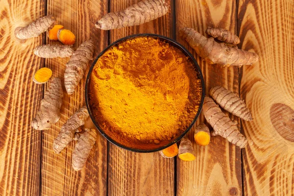 木制背景上的姜黄粉和姜黄根的头顶 — 图库照片