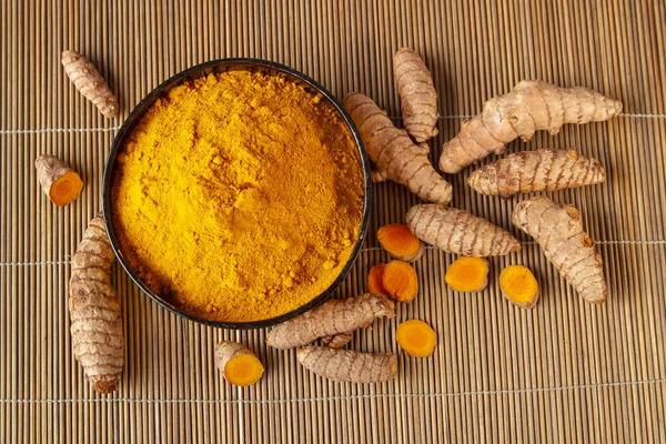 姜黄根和粉末在竹餐巾顶视图 — 图库照片
